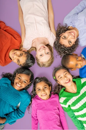 Grupo de alunos do Fundamental II sorrindo deitados em círculo no Colégio Antônio Villas Boas em Osasco.