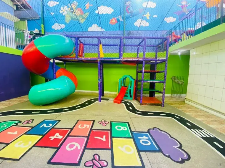 Playground colorido com escorregador e casinha na área de recreação do Colégio Antônio Villas Boas em Osasco.