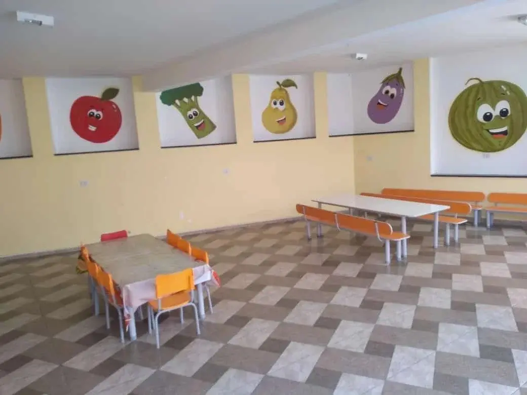 Refeitório infantil com mesas adequadas à altura e decoração de frutas na Unidade Santo Antônio, Osasco.