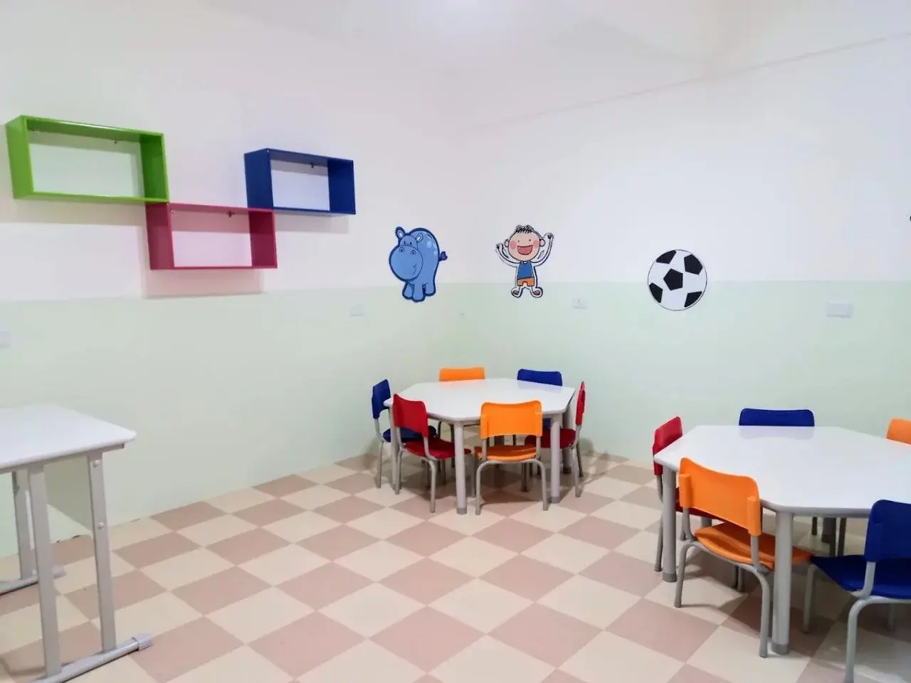 Sala de atividades do Maternal com mesas hexagonais que incentivam o trabalho em grupo e a interação social na Unidade Santo Antônio (Osasco).