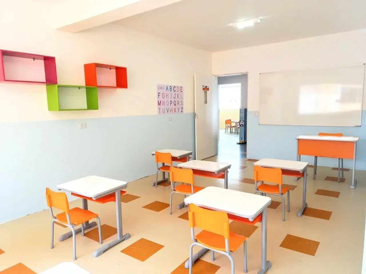 Sala de aula de alfabetização com carteiras individuais organizadas e alfabeto na parede na Unidade Santo Antônio do Colégio AVB.